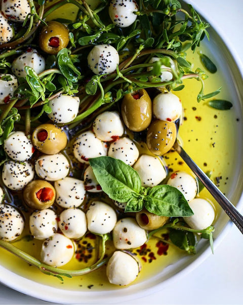 Eine Schüssel mit Minos BIO Grünen Oliven mit Paprika, gefüllt mit frischer Paprika und umgeben von aromatischen Kräutern in einer schmackhaften Olivenölmarinade. Diese köstliche Mischung ist ideal für mediterrane Gerichte und sorgt für ein authentisches Geschmackserlebnis. Die Oliven sind perfekt für Salate, als Snack oder als Beilage zu verschiedenen Hauptgerichten und verleihen jedem Gericht eine besondere Note.